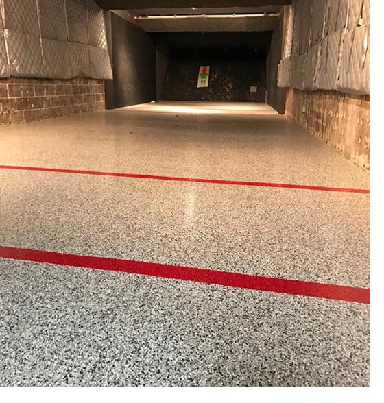 Epoxy floor with safety striping in an indoor shooting range